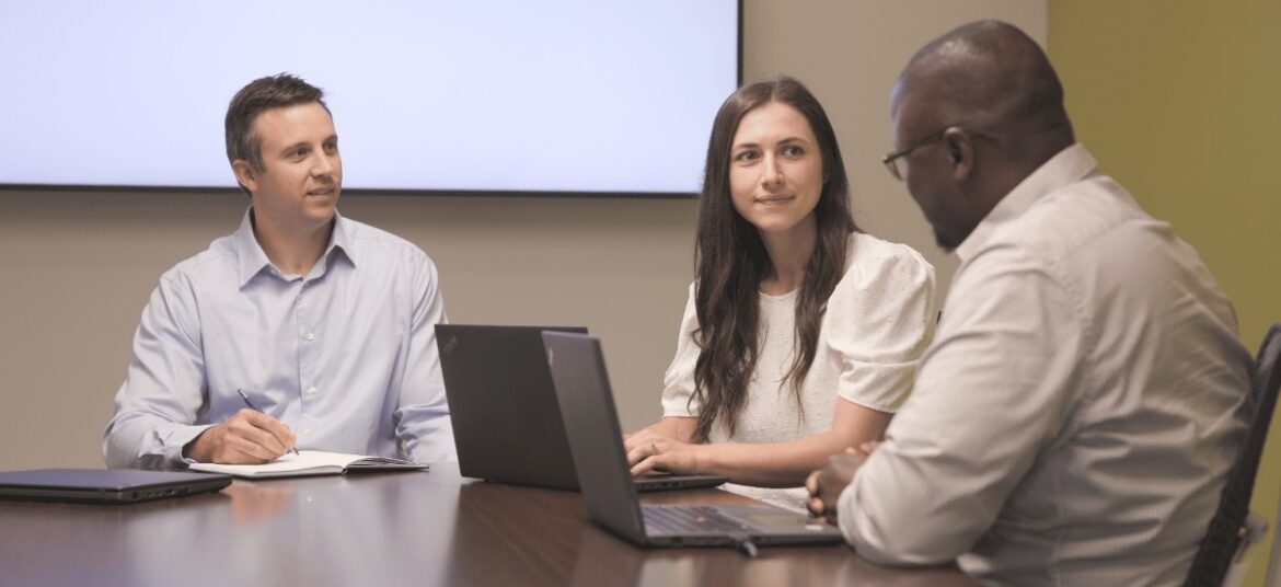 3 people having a meeting in a conference room